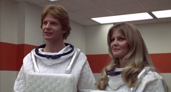 Movie still from “Futureworld” (1976), directed by Richard T. Heffron – A man and a woman in space suits standing next to each other; Medium shot, Low angle