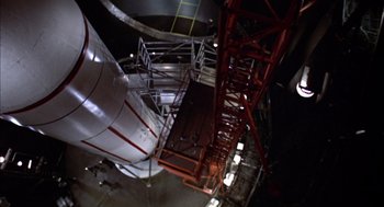Movie still from “Futureworld” (1976), directed by Richard T. Heffron – Looking up at a large metal structure in a dark room; Extreme Wide shot, Overhead angle