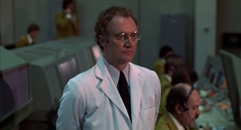 Movie still from “Futureworld” (1976), directed by Richard T. Heffron – A man in a white lab coat standing in front of other men; Medium shot, Low angle