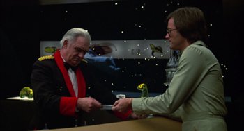 Movie still from “Futureworld” (1976), directed by Richard T. Heffron – A man in a red jacket and a man in a green shirt holding a knife; Medium shot, Over the shoulder angle