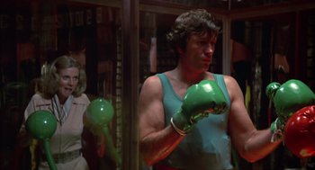 Movie still from “Futureworld” (1976), directed by Richard T. Heffron – A man in a green boxing glove stands in front of a window; Medium shot, Low angle