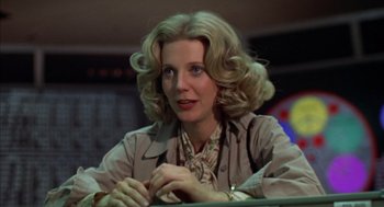 Movie still from “Futureworld” (1976), directed by Richard T. Heffron – A woman sitting in front of a table; Close Up shot, Low angle