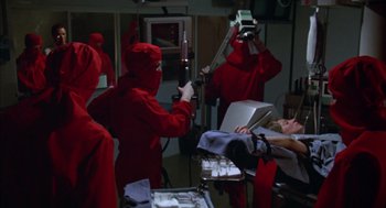 Movie still from “Futureworld” (1976), directed by Richard T. Heffron – A group of people dressed in red in an operating room; Medium shot, High angle