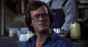 Movie still from “Futureworld” (1976), directed by Richard T. Heffron – A person wearing glasses in a room; Close Up shot, Low angle