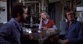 Movie still from “Futureworld” (1976), directed by Richard T. Heffron – A man and a woman sitting at a table in a room; Medium shot, Over the shoulder angle