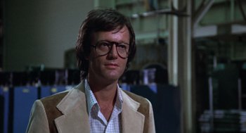 Movie still from “Futureworld” (1976), directed by Richard T. Heffron – A person wearing glasses and a jacket; Close Up shot, Over the shoulder angle