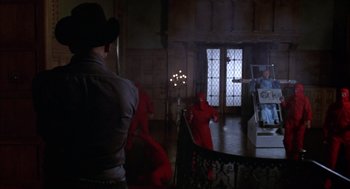 Movie still from “Futureworld” (1976), directed by Richard T. Heffron – A group of people dressed up in red costumes in a room; Wide shot, Over the shoulder angle