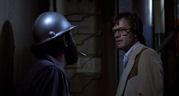 Movie still from “Futureworld” (1976), directed by Richard T. Heffron – A man with a pipe and a man with glasses; Close Up shot, Over the shoulder angle