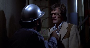 Movie still from “Futureworld” (1976), directed by Richard T. Heffron – A man wearing a hard hat is talking to another man; Close Up shot, Over the shoulder angle