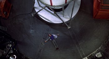 Movie still from “Futureworld” (1976), directed by Richard T. Heffron – A man laying on the ground in a building; Extreme Wide shot, Overhead angle