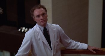 Movie still from “Futureworld” (1976), directed by Richard T. Heffron – A man in a white lab coat standing in front of a railing; Medium shot, Low angle