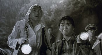 Movie still from “Gamera 3: Revenge of Iris” (1999), directed by Shûsuke Kaneko – A man and a woman standing next to each other; Medium shot, Low angle