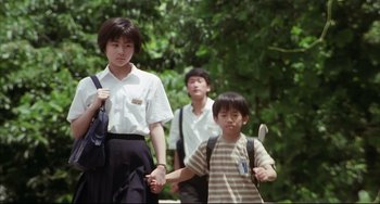 Movie still from “Gamera 3: Revenge of Iris” (1999), directed by Shûsuke Kaneko – A group of young people holding hands while walking down a street; Medium shot, Low angle