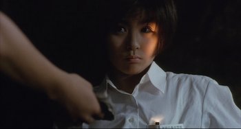Movie still from “Gamera 3: Revenge of Iris” (1999), directed by Shûsuke Kaneko – A woman holding a gun in a dark room; Close Up shot, Low angle