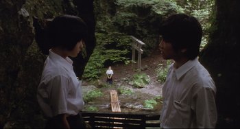 Movie still from “Gamera 3: Revenge of Iris” (1999), directed by Shûsuke Kaneko – Two people standing on a bridge in the woods; Wide shot, Over the shoulder angle