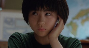 Movie still from “Gamera 3: Revenge of Iris” (1999), directed by Shûsuke Kaneko – A young asian girl holding a cell phone up to her ear; Close Up shot, Low angle