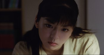 Movie still from “Gamera 3: Revenge of Iris” (1999), directed by Shûsuke Kaneko – A young woman is looking into the camera; Close Up shot, Low angle