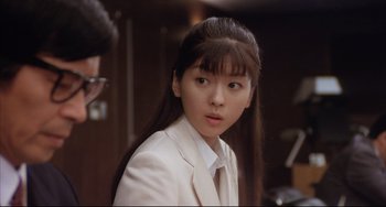 Movie still from “Gamera 3: Revenge of Iris” (1999), directed by Shûsuke Kaneko – A woman in a white jacket and a white shirt; Close Up shot, Over the shoulder angle
