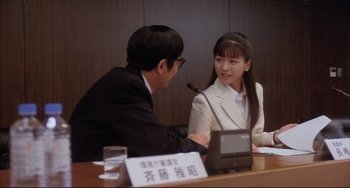 Movie still from “Gamera 3: Revenge of Iris” (1999), directed by Shûsuke Kaneko – A man and a woman sitting at a table talking to each other; Medium shot, Over the shoulder angle