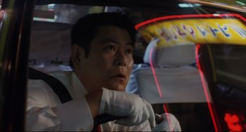 Movie still from “Gamera 3: Revenge of Iris” (1999), directed by Shûsuke Kaneko – A man sitting in the back seat of a car; Close Up shot, Low angle