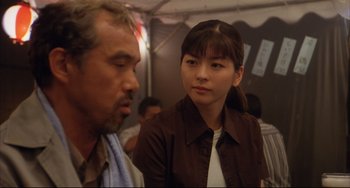 Movie still from “Gamera 3: Revenge of Iris” (1999), directed by Shûsuke Kaneko – A man and a woman sitting next to each other; Close Up shot, Over the shoulder angle