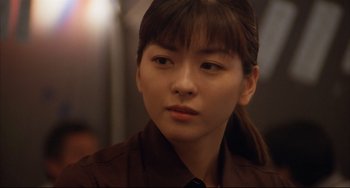 Movie still from “Gamera 3: Revenge of Iris” (1999), directed by Shûsuke Kaneko – A young woman with long hair wearing a dress shirt and tie; Close Up shot, Over the shoulder angle