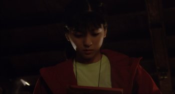 Movie still from “Gamera 3: Revenge of Iris” (1999), directed by Shûsuke Kaneko – A young girl is looking at a tablet computer; Close Up shot, High angle