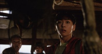 Movie still from “Gamera 3: Revenge of Iris” (1999), directed by Shûsuke Kaneko – A woman in a red jacket is looking at the camera; Close Up shot, Low angle