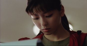 Movie still from “Gamera 3: Revenge of Iris” (1999), directed by Shûsuke Kaneko – A young woman looking down at her cell phone; Close Up shot, Low angle