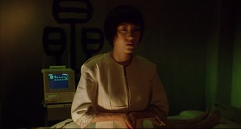 Movie still from “Gamera 3: Revenge of Iris” (1999), directed by Shûsuke Kaneko – A woman standing in front of a computer monitor; Medium shot, Low angle