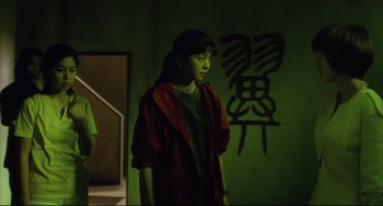 Movie still from “Gamera 3: Revenge of Iris” (1999), directed by Shûsuke Kaneko – A woman standing in front of a mirror in the dark; Medium shot, Low angle