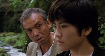 Movie still from “Gamera 3: Revenge of Iris” (1999), directed by Shûsuke Kaneko – A man and a young boy looking at each other; Close Up shot, Over the shoulder angle
