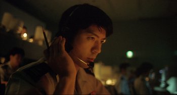 Movie still from “Gamera 3: Revenge of Iris” (1999), directed by Shûsuke Kaneko – A man with a headset is looking at the camera; Close Up shot, Low angle