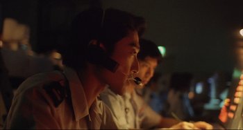 Movie still from “Gamera 3: Revenge of Iris” (1999), directed by Shûsuke Kaneko – A man with a headset on sitting in front of a computer; Close Up shot, Low angle