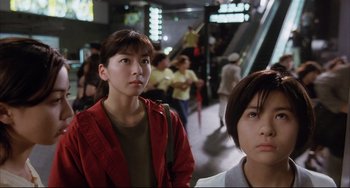 Movie still from “Gamera 3: Revenge of Iris” (1999), directed by Shûsuke Kaneko – Two women are standing in a subway station; Close Up shot, Low angle