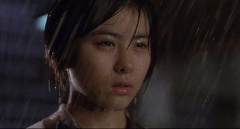 Movie still from “Gamera 3: Revenge of Iris” (1999), directed by Shûsuke Kaneko – A young woman is standing in the pouring rain; Close Up shot, Low angle
