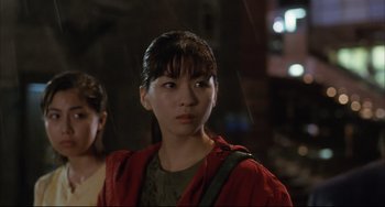 Movie still from “Gamera 3: Revenge of Iris” (1999), directed by Shûsuke Kaneko – A woman in a red jacket standing next to another woman in a green jacket; Close Up shot, Low angle