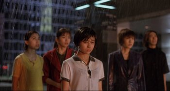 Movie still from “Gamera 3: Revenge of Iris” (1999), directed by Shûsuke Kaneko – A group of people standing next to each other in the rain; Medium shot, Low angle