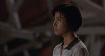 Movie still from “Gamera 3: Revenge of Iris” (1999), directed by Shûsuke Kaneko – A young girl is standing in the dark; Close Up shot, Low angle