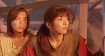 Movie still from “Gamera 3: Revenge of Iris” (1999), directed by Shûsuke Kaneko – A woman with long red hair is looking to her left; Close Up shot, Low angle