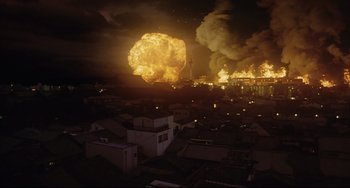 Movie still from “Gamera 3: Revenge of Iris” (1999), directed by Shûsuke Kaneko – An explosion is seen in the background of a city at night; Extreme Wide shot, High angle