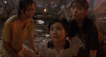 Movie still from “Gamera 3: Revenge of Iris” (1999), directed by Shûsuke Kaneko – A group of women standing next to each other on the ground; Medium shot, Low angle