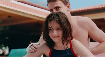 Movie still from “Aftersun” (2022), directed by Charlotte Wells – A young girl and a young man posing for a picture; Close Up shot, Over the shoulder angle