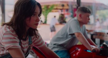 Movie still from “Aftersun” (2022), directed by Charlotte Wells – A woman sitting next to a man on a bench; Medium shot, Over the shoulder angle