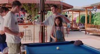 Movie still from “Aftersun” (2022), directed by Charlotte Wells – A man and a woman playing pool in a bar; Medium shot, Over the shoulder angle