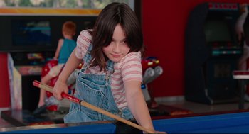 Movie still from “Aftersun” (2022), directed by Charlotte Wells – A young girl is playing a game of billiards; Close Up shot, Low angle