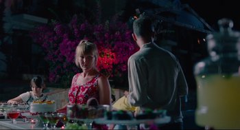 Movie still from “Aftersun” (2022), directed by Charlotte Wells – A man and a woman standing next to each other at a table; Medium shot, Over the shoulder angle