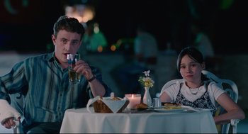 Movie still from “Aftersun” (2022), directed by Charlotte Wells – A man and a woman sitting at a dinner table; Medium shot, Over the shoulder angle