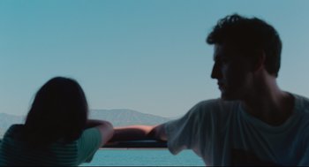 Movie still from “Aftersun” (2022), directed by Charlotte Wells – A man and a woman standing next to a body of water; Close Up shot, Over the shoulder angle