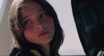 Movie still from “Aftersun” (2022), directed by Charlotte Wells – A young girl is looking out the window of a car; Close Up shot, Low angle